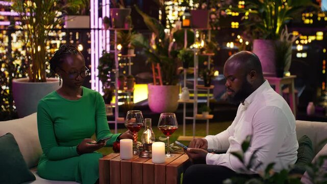 Partners struggle with relationship problems as smartphones replace conversation during date night and both focus on their devices instead of each other.
