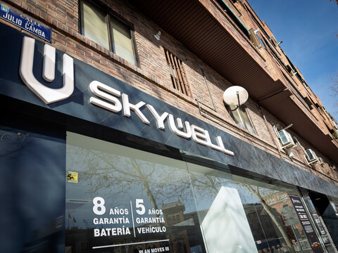 MADRID, SPAIN - FEBRUARY 22, 2026: Skywell logo above a car dealership on Calle Julio Camba. The Chinese electric vehicle brand promotes battery and vehicle warranties on the showroom windows beneath 