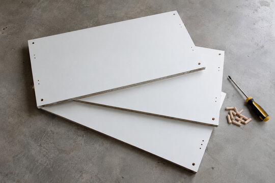 Flat-pack shelving panels with dowels and a screwdriver