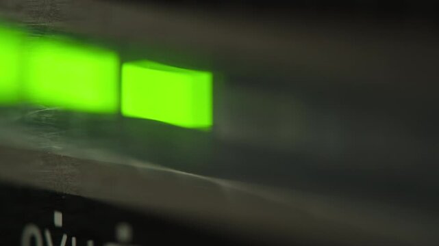 Analog dial indicator of audio signal level amplifier. Vintage arrow moves with sound level. Round classic volume indicator with yellow backlight, VU meters. Close-up of old measuring dB decibels