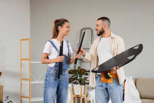 Home improvement and renovation, young couple assembling furniture together in new apartment with teamwork and DIY project lifestyle in living room