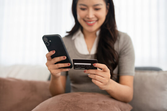 Woman holding mobile phone and credit card makingonline payments, enjoy remote shopping technology and digital wallet application. cashless lifestyle