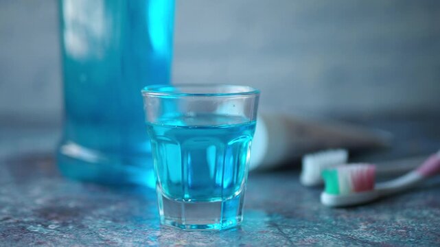 Using mouthwash with toothbrushes and toothpaste on a bathroom counter