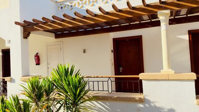 Luxury villa building facade with wooden pergola and tiled roof in Sharm El Sheikh resort, Egypt. Five star hotel architecture at sunny day, beautiful background for summer travel vacation concept.
