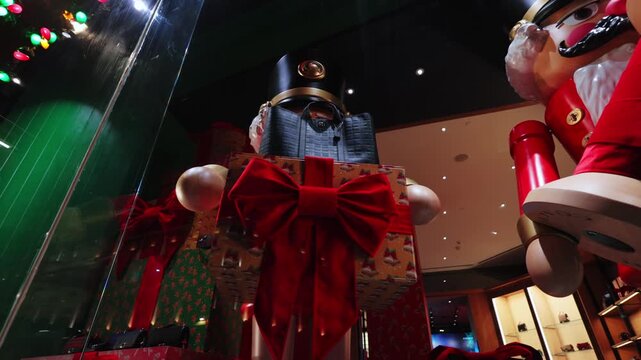 A nutcracker figure and gift boxes fill a London shop window on Christmas Eve