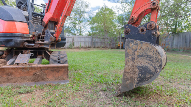 Heavy excavator digs trench for drainage pipe at Construccion site during excavation work.