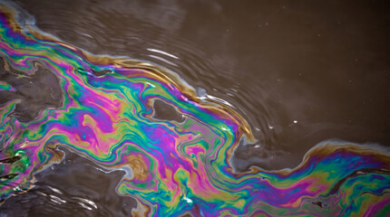 Fototapeta premium Abstract oil slick texture creates colorful environmental crisis background with swirling iridescent pattern. Global climate change drought disaster earth nature ecology abstract ground surface