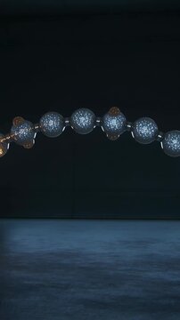 Vertical video: Emerging golden pulse traveling through bead chain in dark studio, lighting beads