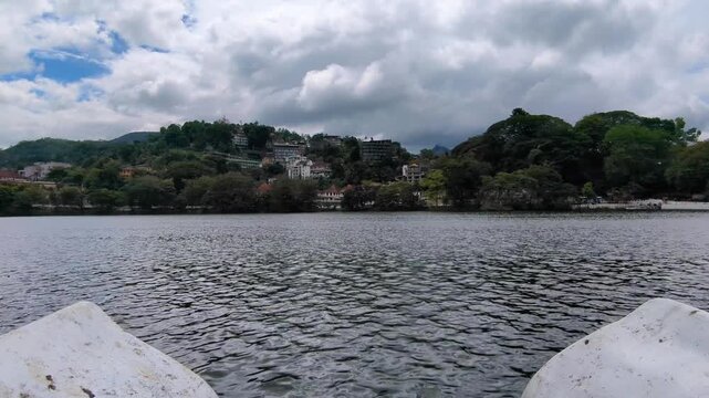 Scenic view overlooking artificial Kandy Lake Kiri Muhuda with houses and hotels on hillside in Kandy City, Sri Lanka