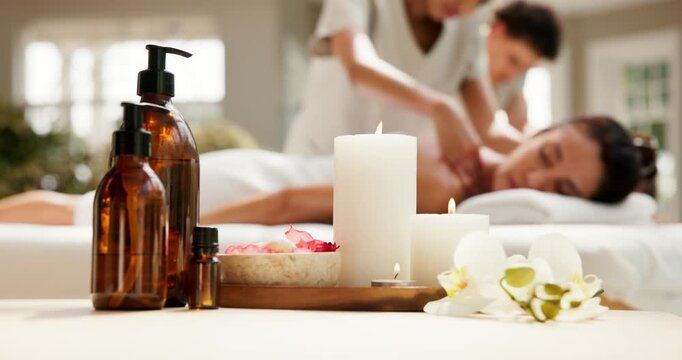 Woman, flowers and candles at spa for massage, essential oil and treatment of deep tissue. Masseuse, female person and ambience at retreat infused scent, holistic healing and therapeutic for wellness