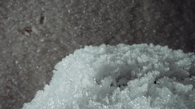 Detailed fallout sample of icy crystals and granular residue, macro view on rough substrate suggesting contamination study visual for laboratory technician measuring sample levels and planning