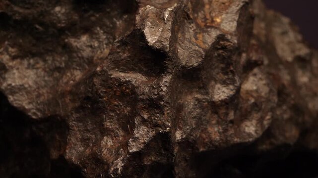 Detailed view of a meteorite specimen displayed in a Prague museum, revealing its irregular rocky form, metallic surface and distinctive extraterrestrial texture.