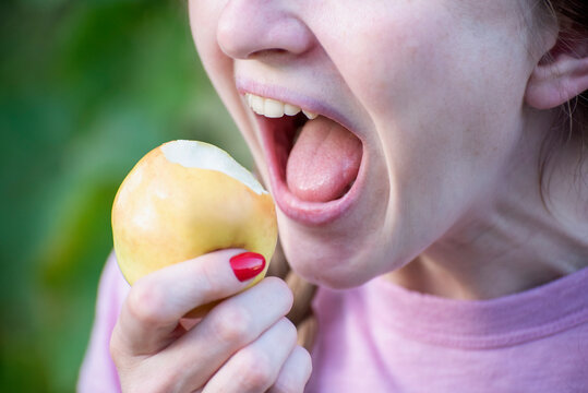 Person ready to bite into a fresh, crisp apple, showing a healthy eating habit and enjoying a nutritious snack with an open, eager mouth