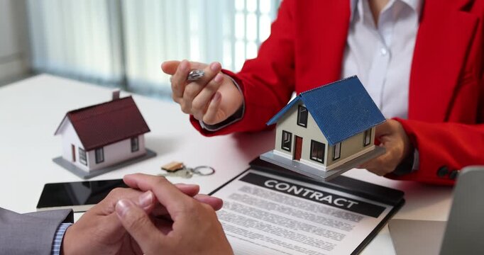 Real estate sales consultation between a property agent and a potential buyer, focusing on house selection, contract negotiation and financial planning to support informed homeownership decisions.