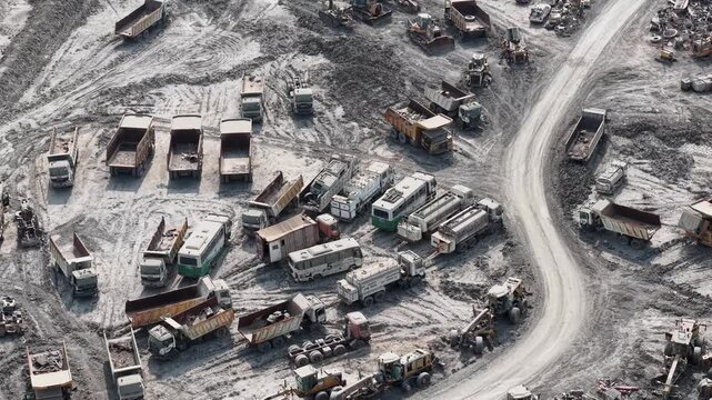 Aerial view of many heavy dump trucks parked in a muddy mining field in South Kalimantan Indonesia