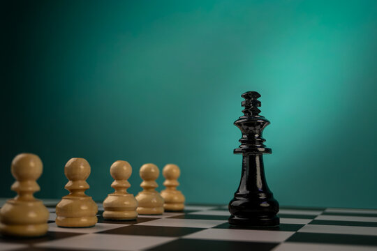 Lone Black King Facing White Pawns and Wooden Chess Pieces