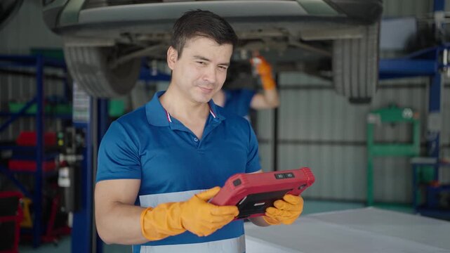 Two technicians are repairing electric cars, checking the batteries at an electric car repair shop.
