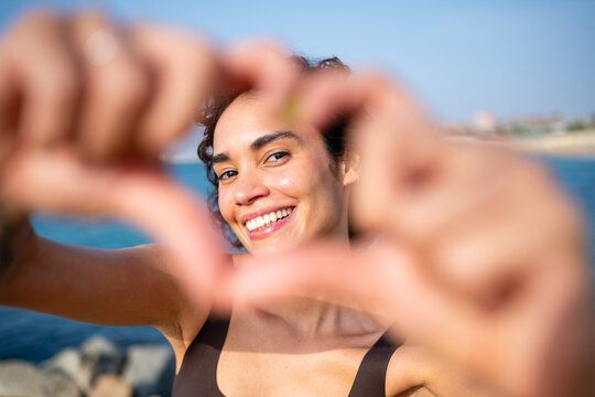 Woman smiling showing heart hands for love concept