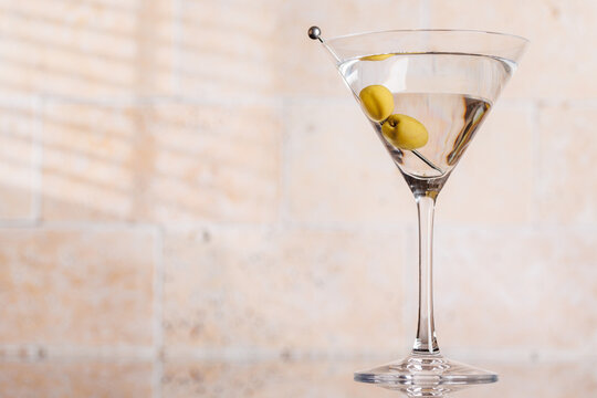 Dry martini with olives against stone wall