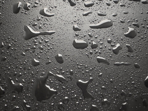 Water droplets on black metal surface