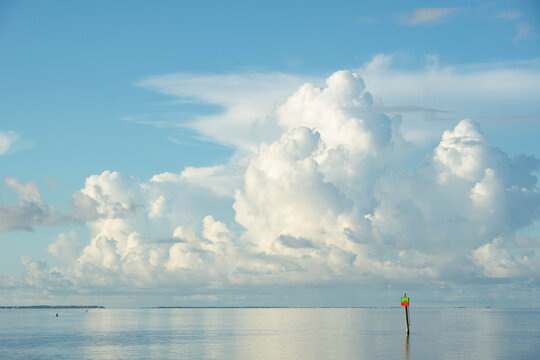 White puffy clouds over channel marker on Apalachicola Bay