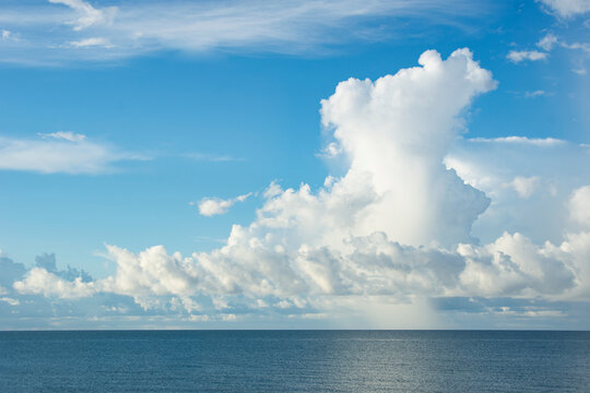 White puffy clouds over calm water
