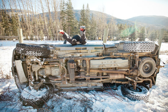 A driver crawls back into his flipped vehicle after an accident