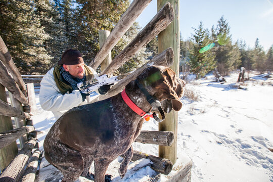 Hunter with his dog on alert in the snow