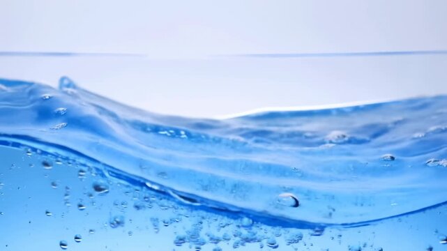 Blue water waves roll across an underwater surface as bubbles rise through the liquid. Hydration advertising, beverage promotion, and wellness media.