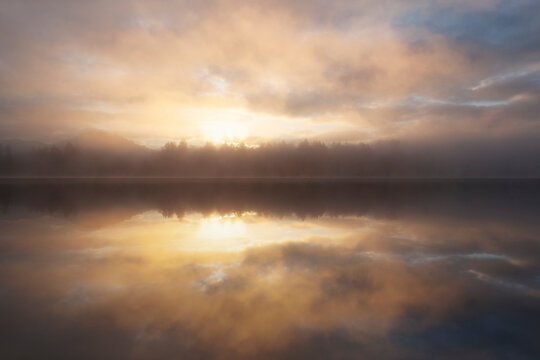 Dramatic sunrise sky reflected in calm lake
