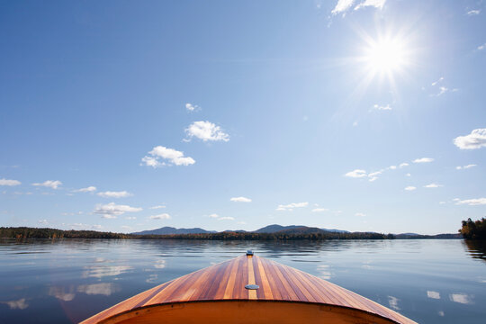 Wooden boat on calm Upper Saranac Lake on sunny day
