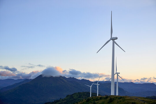 Wind turbines and mountains at sunset