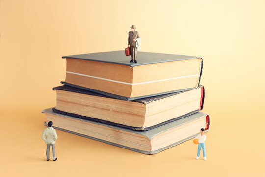 Stack of books and miniature figures. education and learning concept