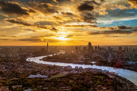 Elevated, panoramic view of the skyline of London, England, during a golden sunset with soft light and cloudscape