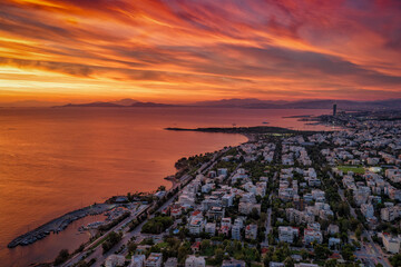Fototapeta premium Aerial view of the southern coast of Athens, Greece, with Voula district, boat marinas and beaches during a colorful sunset