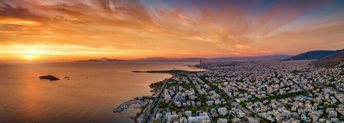 Fototapeta premium Panoramic aerial view of the southern coast of Athens, Greece, with Voula district, boat marinas and beaches during a golden sunset