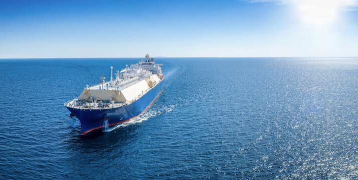 Aerial front view of a large LNG or fossil fuel tanker ship traveling over the ocean as a concept for transport and energy with copy space