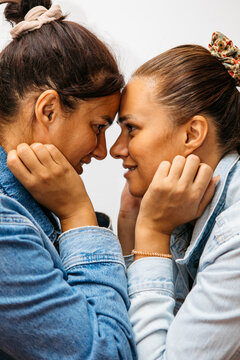 Twin sisters touch foreheads showing affection and bonding