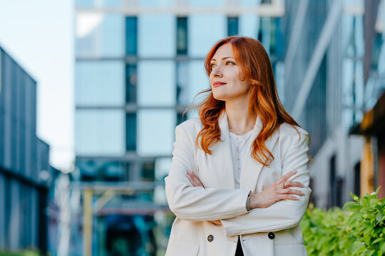 A confident businesswoman crosses her arms in the city