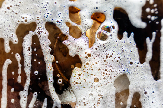 Close-up of foam bubbles on surface of brown liquid drink