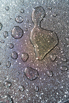 Water droplets creating abstract textured pattern on wet surface