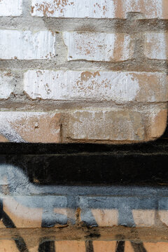 Rough brick wall with weathered white and black paint textures