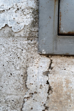 Weathered wall with peeling paint and gray metal frame corner