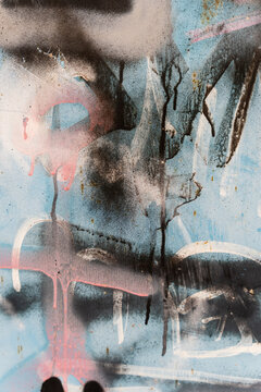 Abstract colorful spray paint texture on weathered blue metal surface