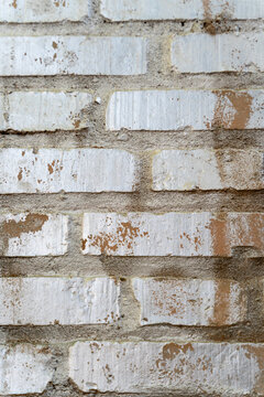 White painted brick wall with weathered cement mortar texture