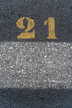 Road surface with yellow number 21 painted on asphalt