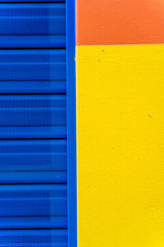 Colorful textured wall corner with blue, yellow, and orange sections