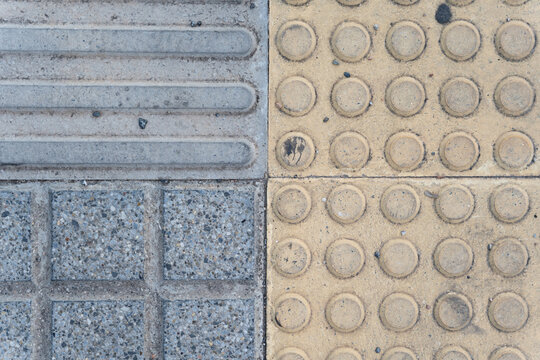 Tactile paving with yellow and gray concrete tiles on urban pedestrian