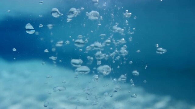 Underwater bubbles rise through blue aquatic space with soft diffused light. Underwater title, aquatic presentation design, and diving and swimming media.