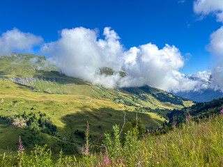 Fototapeta premium Cloudy mountain slopes above alpine meadows in Les Contamines-Montjoie, France
